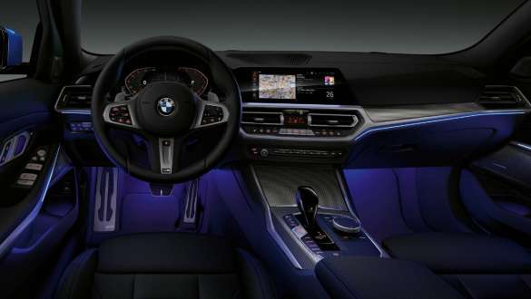 BMW 3 Series Sedan, Ambient light Front view of the driver's cockpit of the BMW 3 Series Sedan with by Ambient light blue illuminated legroom.