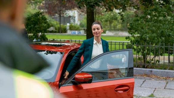 BMW Roadside Assistance BMW Roadside Assistance woman standing in the open door of her BMW