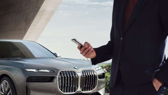 BMW i7 Sedan G70 Digital Key Plus Smartphone in front of car door