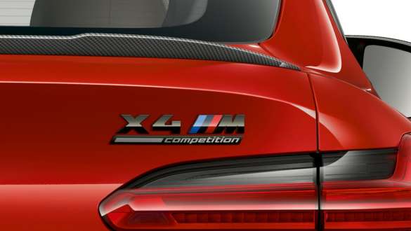 BMW X4 M Competition, rear with “X4 M Competition” designation. BMW X4 M Competition in Toronto Red metallic, exterior, close-up view rear with rear spoiler in carbon and “X4 M Competition” designation.