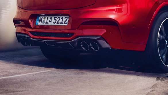 M Sport exhaust system. BMW X4 M Competition in Toronto Red metallic, exterior, rear view with M Sport exhaust system and diffusor in carbon.