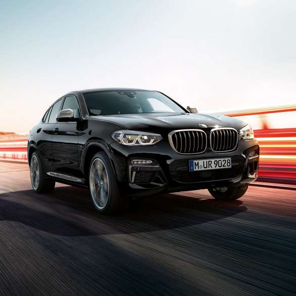 BMW X4 M40i, three-quarter rear view. BMW X4 M40i in Black Sapphire metallic, driving, exterior, three-quarter rear view with light strips.
