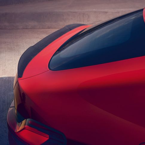 BMW X4 M Competition, M rear spoiler in carbon. BMW X4 M Competition in Toronto Red metallic, exterior, M Carbon exterior package, detailed rear view with M rear spoiler in carbon.
