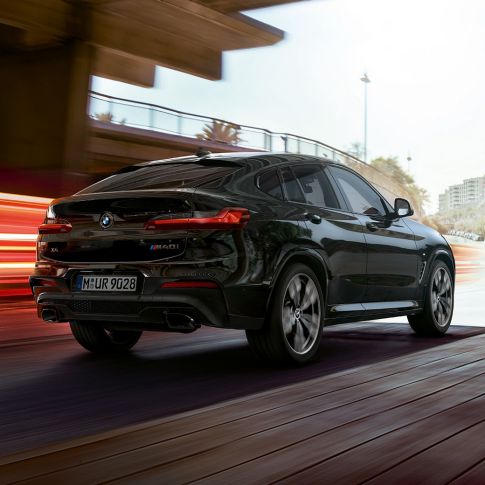 BMW X4 M40i, three-quarter rear view. BMW X4 M40i in Black Sapphire metallic, exterior, three-quarter rear view, right side with light strips.