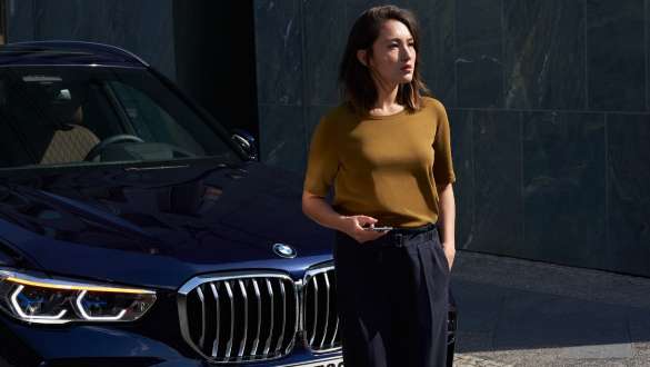BMW Roadside Assistance Woman in front of a BMW 