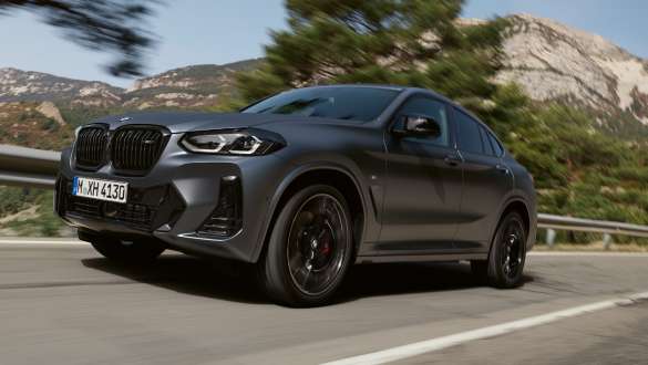 M Sport suspension BMW X4 M40i M40d G02 LCI Facelift 2021 front view driving BMW X4 M40i M40d G02 LCI 2021 Frozen Deep Grey M Sport suspension three-quarter front view driving in front of hills