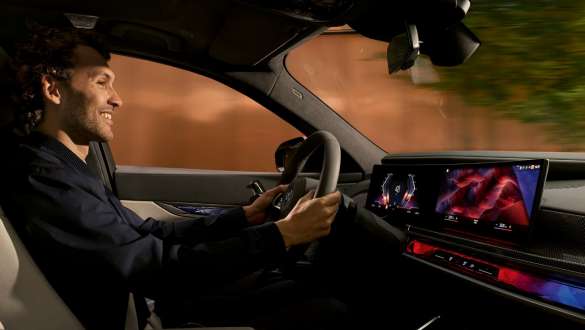 BMW intérieur homme regardant sur le BMW Curved Display BMW intérieur homme dans le poste de conduite regardant sur le BMW Curved Display