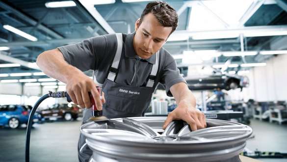 Un employé du service BMW répare la roue d’une BMW. Un employé du service BMW répare la roue d’une BMW.
