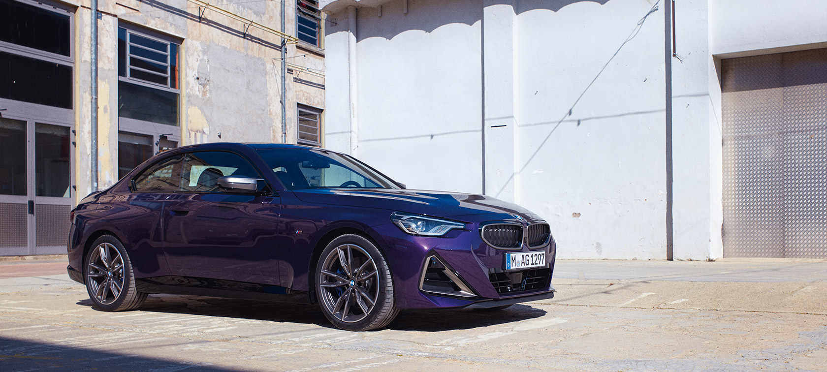 Vue de trois quarts de profil de la BMW Série 2 Coupé G42 2021 BMW Série 2 Coupé G42 2021 Thundernight metallic vue de trois quarts de profil à l’arrêt devant bâtiment