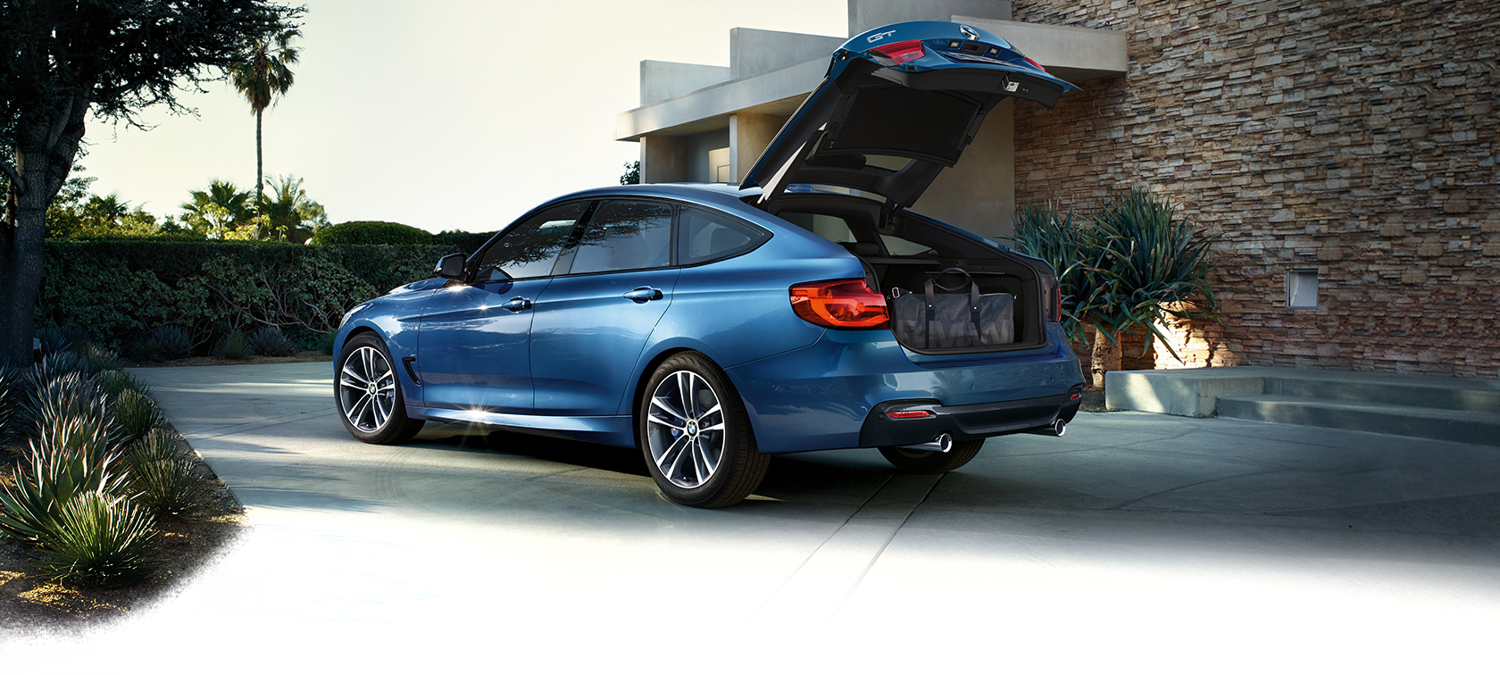 BMW 3 Series Gran Turismo: bright blue car with open trunk. BMW 3 Series Gran Turismo: bright blue car with open trunk.