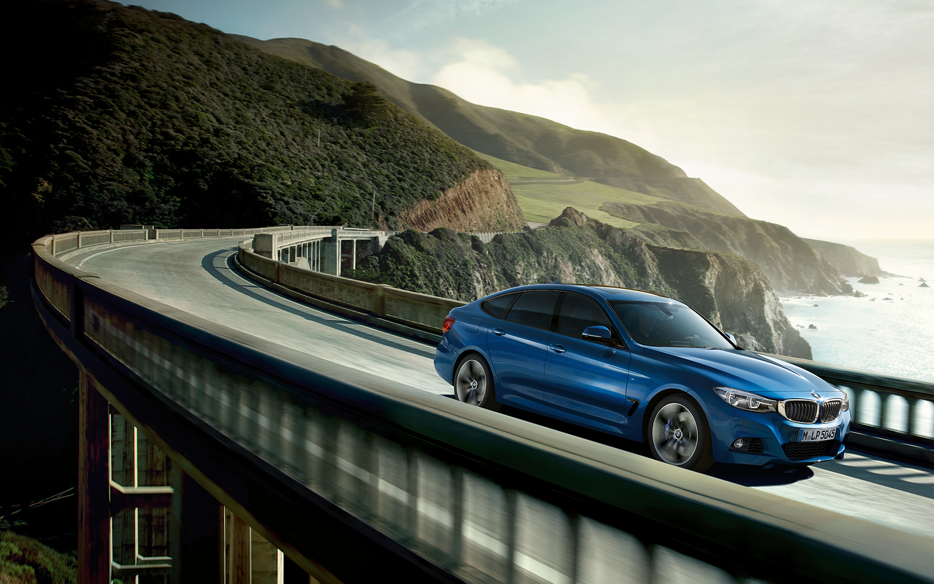 BMW 3 Series Gran Turismo: bright blue car fast driving on the highway bridge. BMW 3 Series Gran Turismo: bright blue car fast driving on the highway bridge.