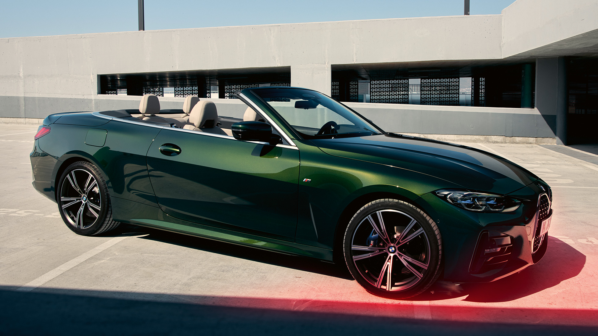 Vue de trois quarts avant de la BMW Série 4 Cabrio G23 2020 avec homme BMW Série 4 Cabrio G23 2020 Sanremo Green metallic, vue de trois quarts avant avec homme à côté
