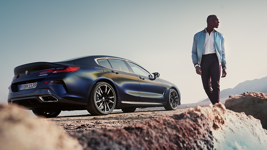 La nouvelle BMW Série 8 Gran Coupé G16 LCI restylage vue de trois quarts arrière avec modèle homme vue en contre plongée