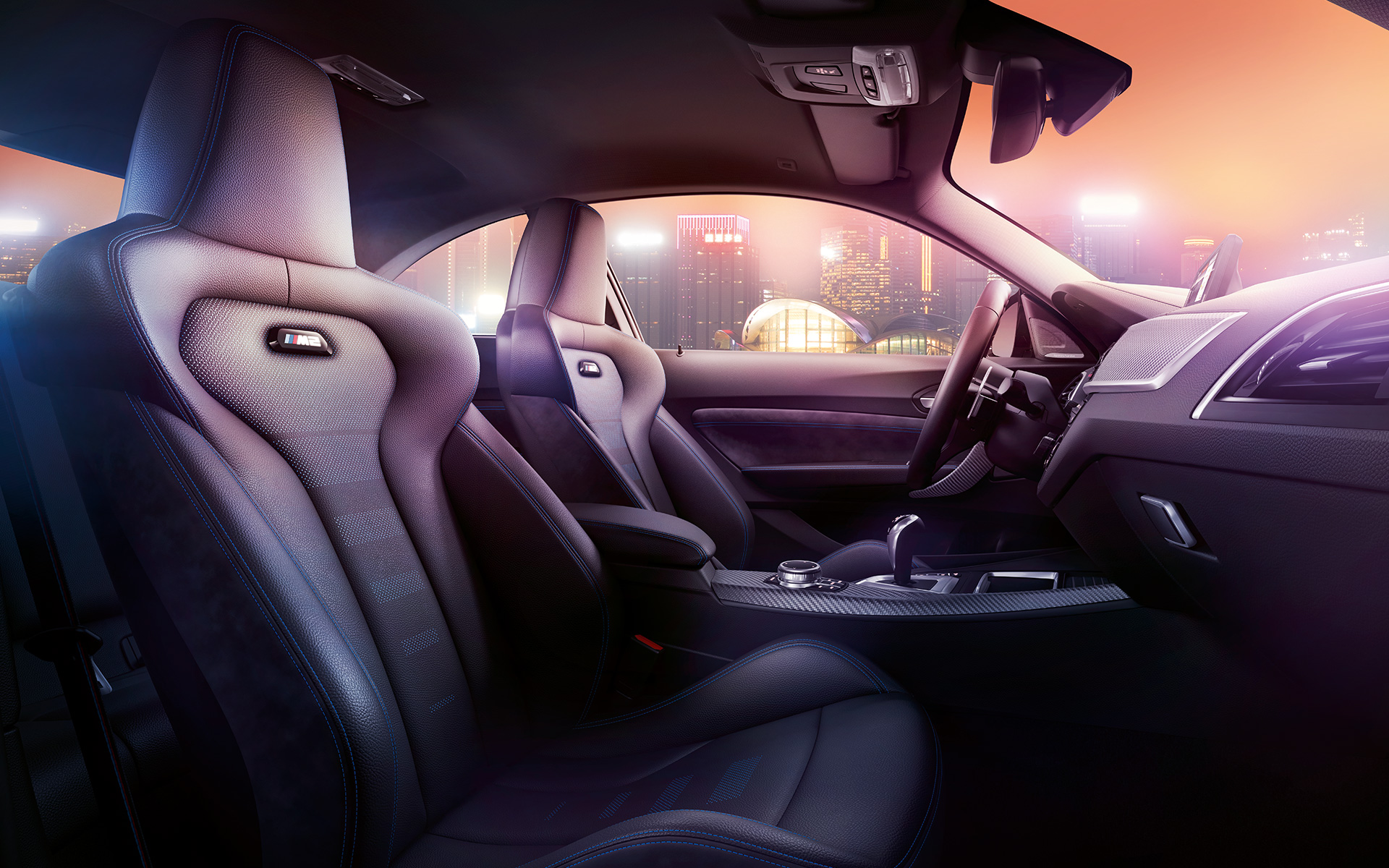 BMW M2 Competition Sport seats Cockpit and M Sport seats of the BMW M2 Competition, nocturnal skyline in the background.