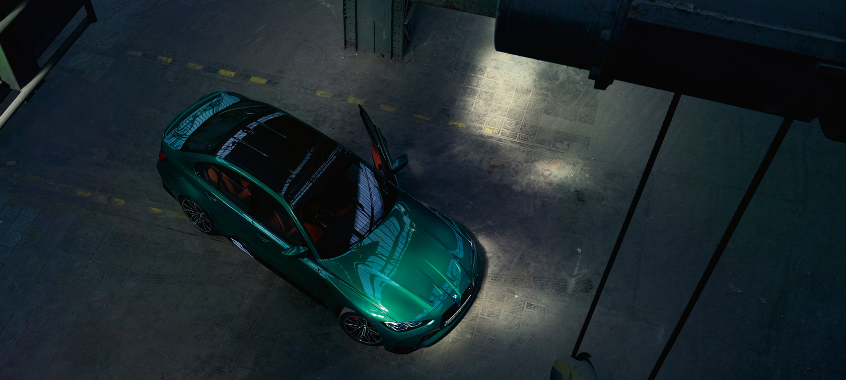 Vue en plongée de la BMW M3 Berline G80 2020 avec porte ouverte Vue en plongée de la BMW M3 Berline G80 2020 Isle of Man Grün metallic avec porte ouverte