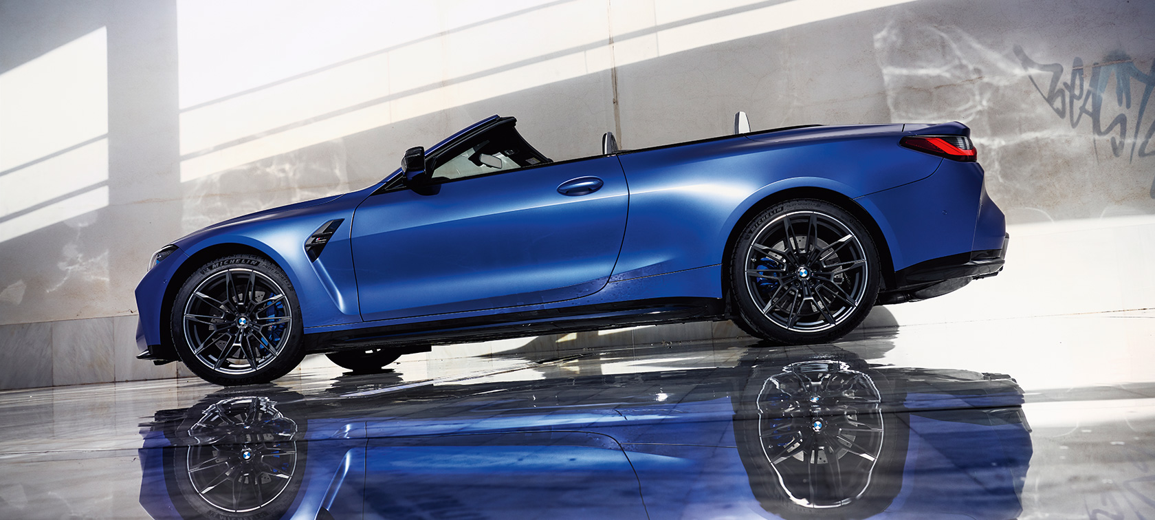 BMW M4 Competition Cabriolet with M xDrive G83 2021 side view low angle shot BMW M4 Competition Cabriolet with M xDrive G83 2021 BMW Individual Frozen Portimao Blue metallic side view standing low angle shot