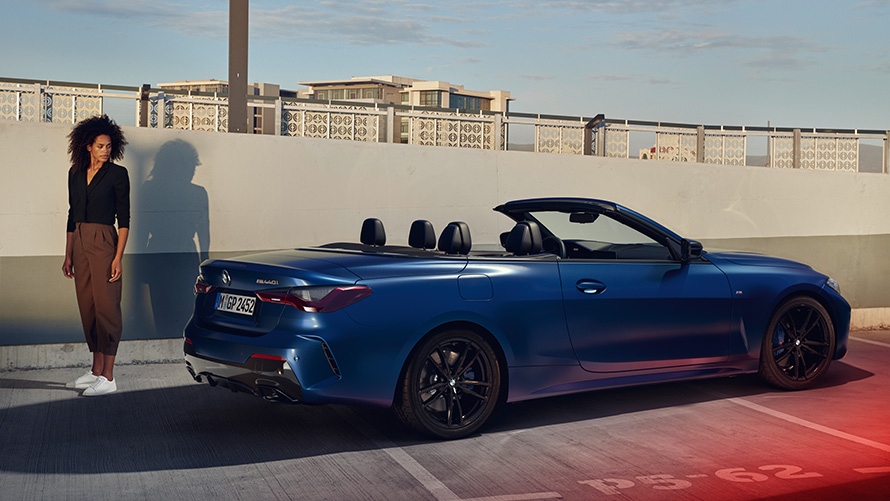 BMW Financial Services pour la BMW Série 4 Cabrio. Femme se trouvant derrière une BMW Série 4 Cabrio sur un parking, BMW Financial Services
