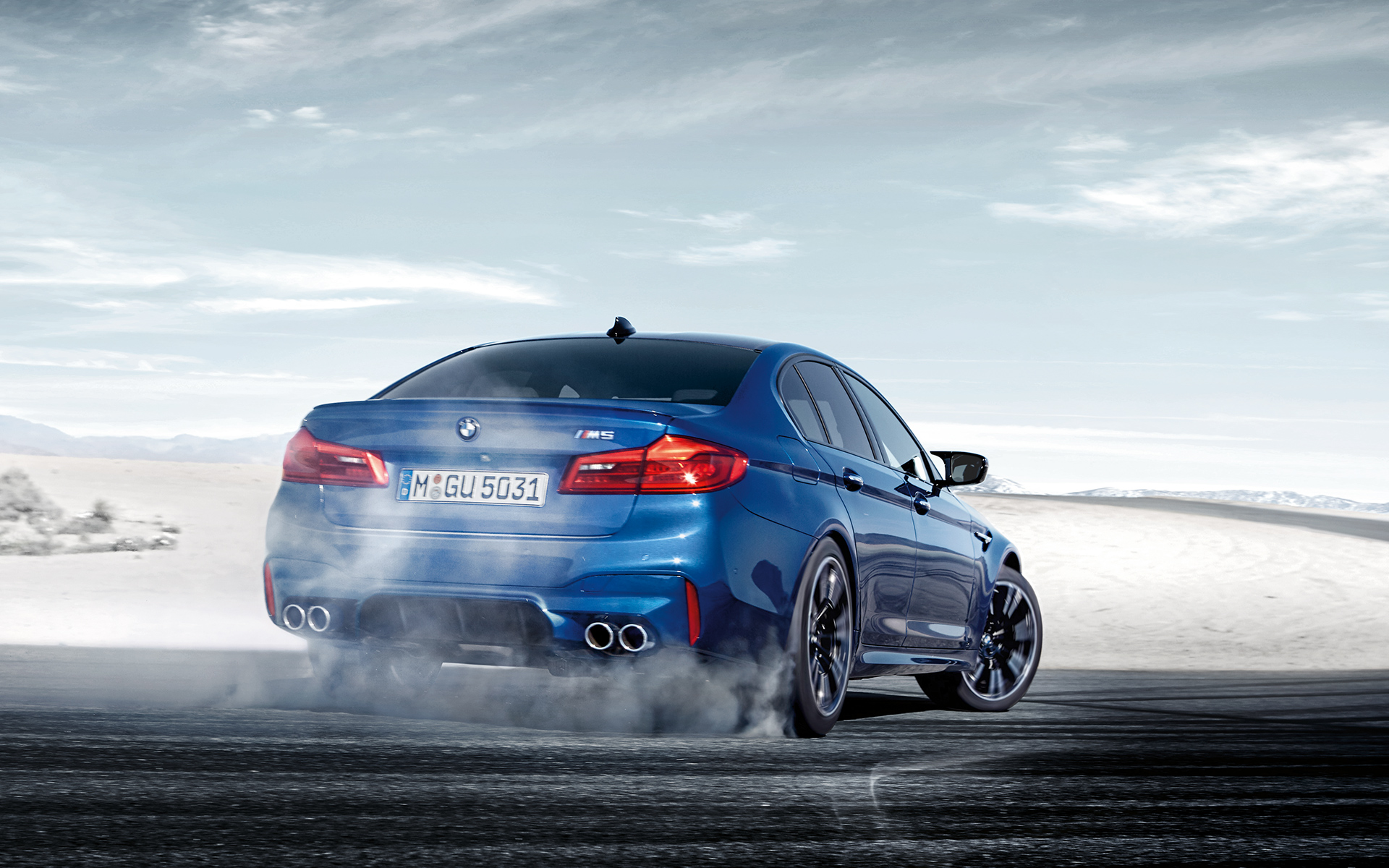 BMW M Series M5 Sedan: bright blue rear view of drifting car. BMW M Series M5 Sedan: bright blue rear view of drifting car.