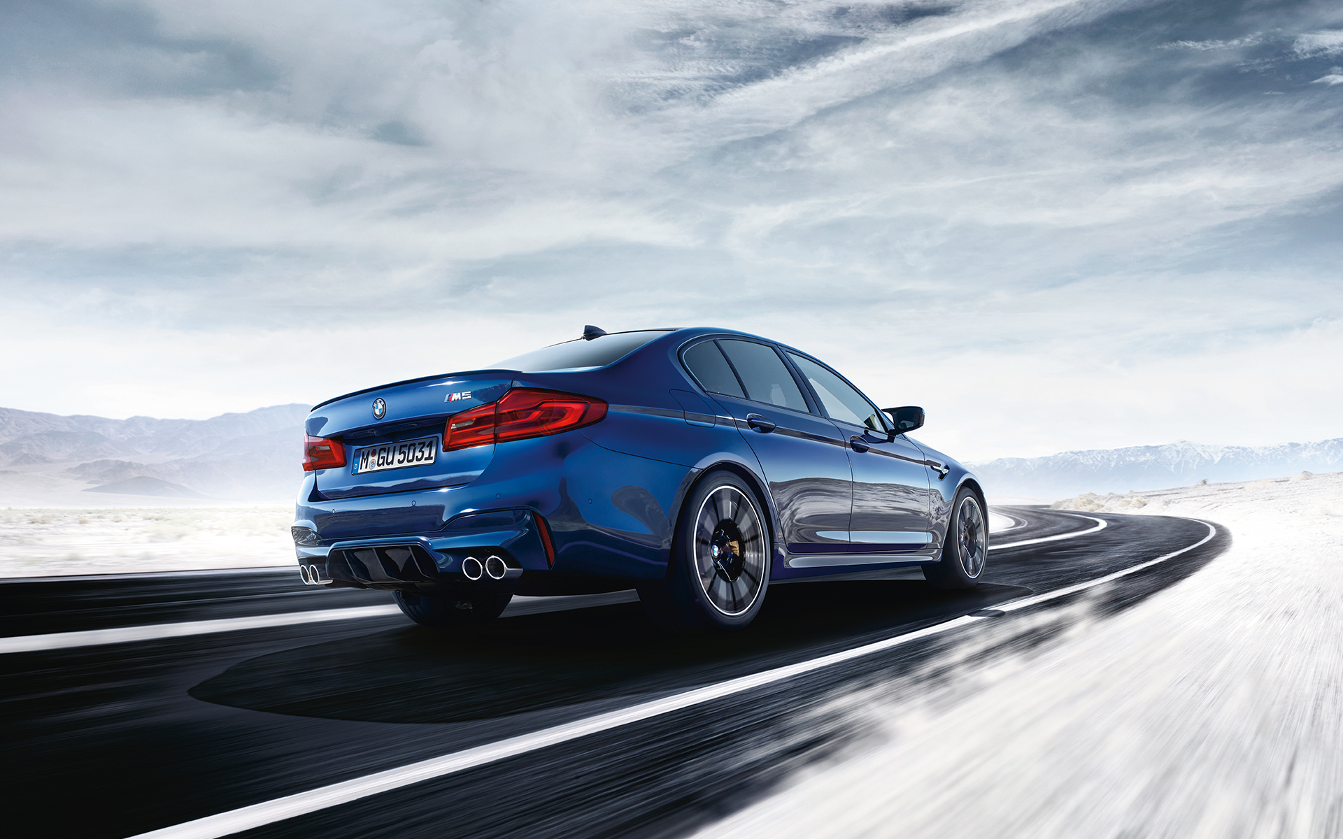 BMW M Series M5 Sedan: bright blue rear view car fast moving on the road. BMW M Series M5 Sedan: bright blue rear view car fast moving on the road.