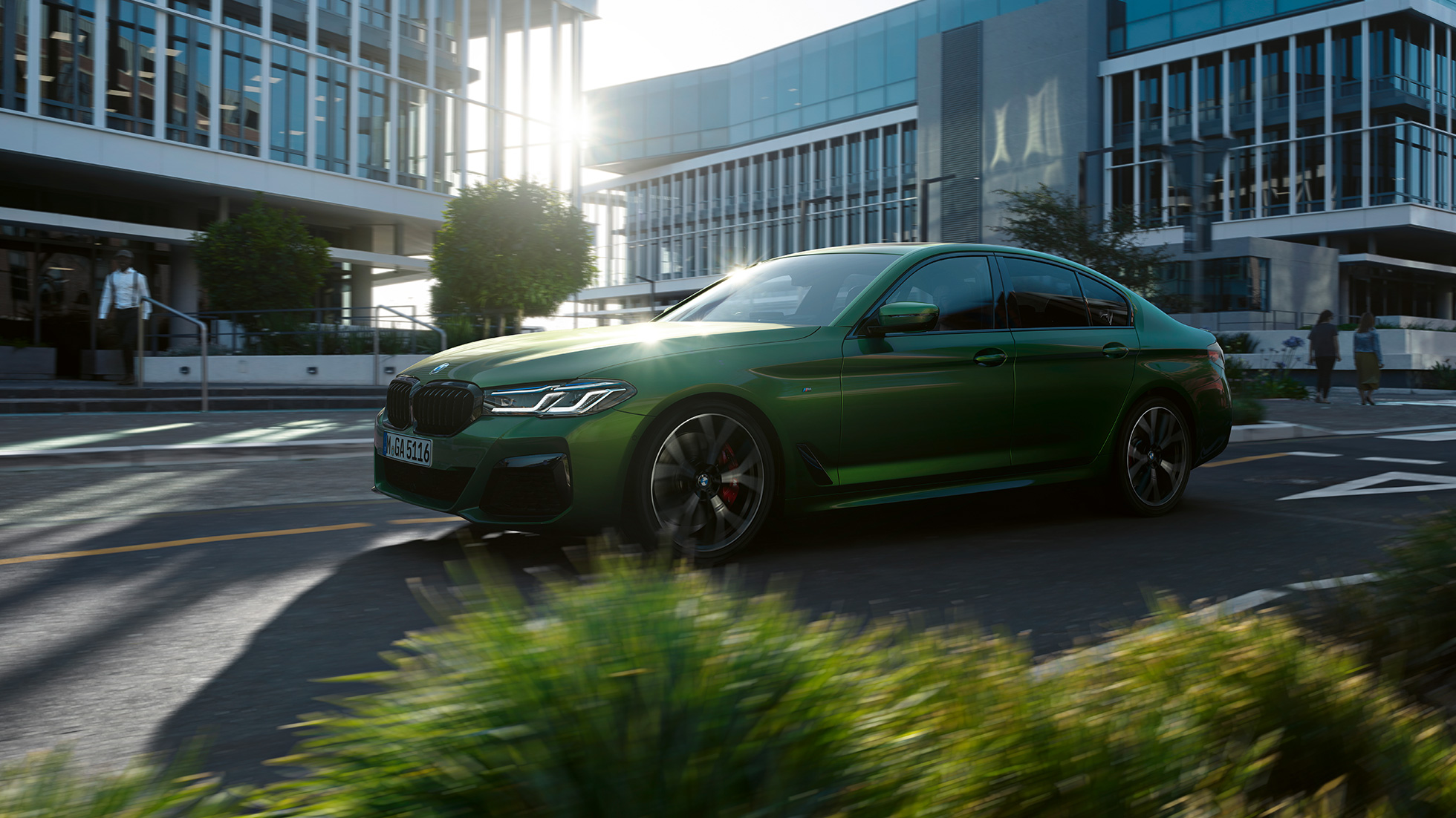 BMW M550i xDrive Berline G30 LCI restylage 2020 vue de profil en conduite BMW M550i xDrive Berline G30 LCI restylage 2020 BMW Individual Verde Ermes metallic vue de profil en conduite en ville