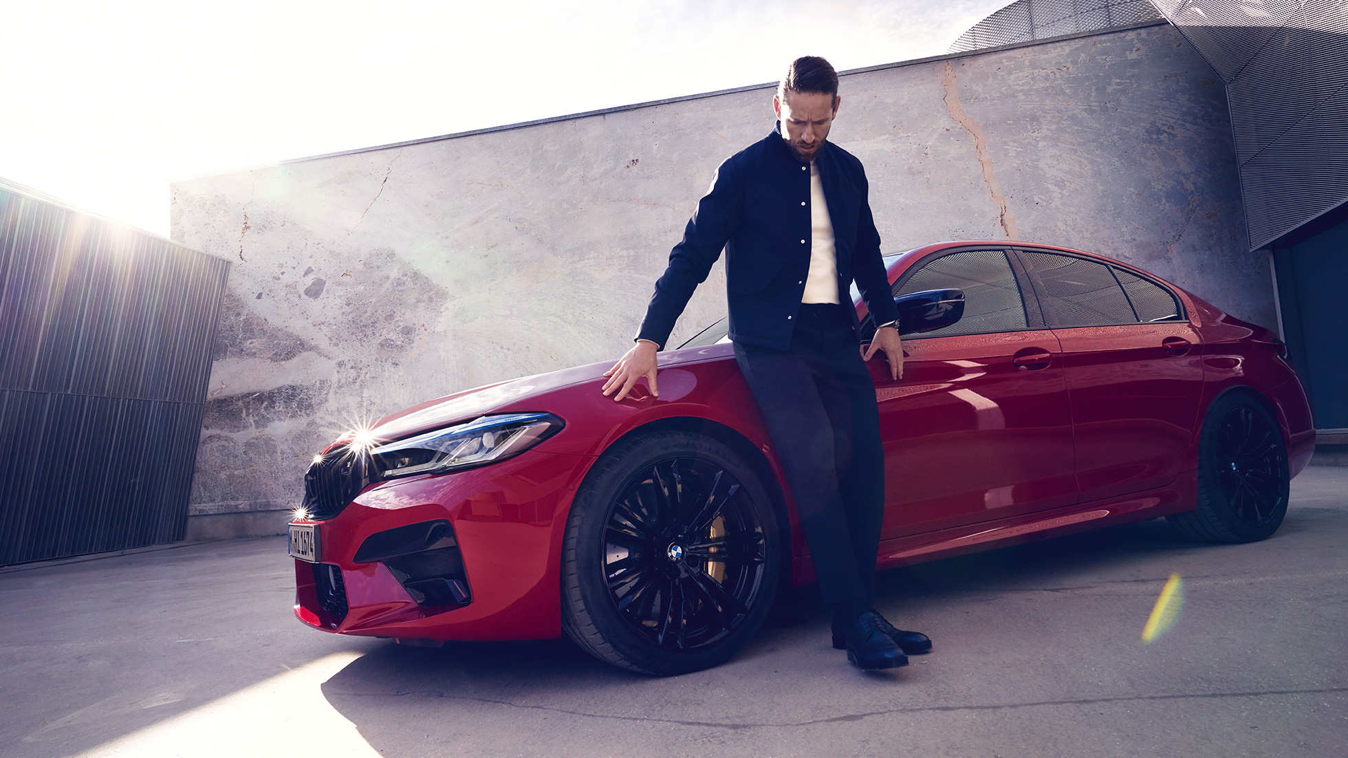 BMW M5 Competition F90 LCI restylage 2020 vue de profil avec homme BMW M5 Competition F90 LCI restylage 2020 BMW Individual Imola Rot vue de profil avec homme