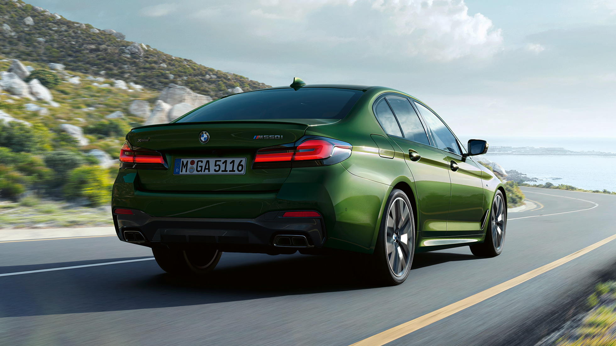 BMW M550i xDrive Berline G30 LCI restylage 2020 vue arrière BMW M550i xDrive Berline G30 LCI restylage 2020 BMW Individual Verde Ermes metallic vue arrière en conduite sur route de campagne