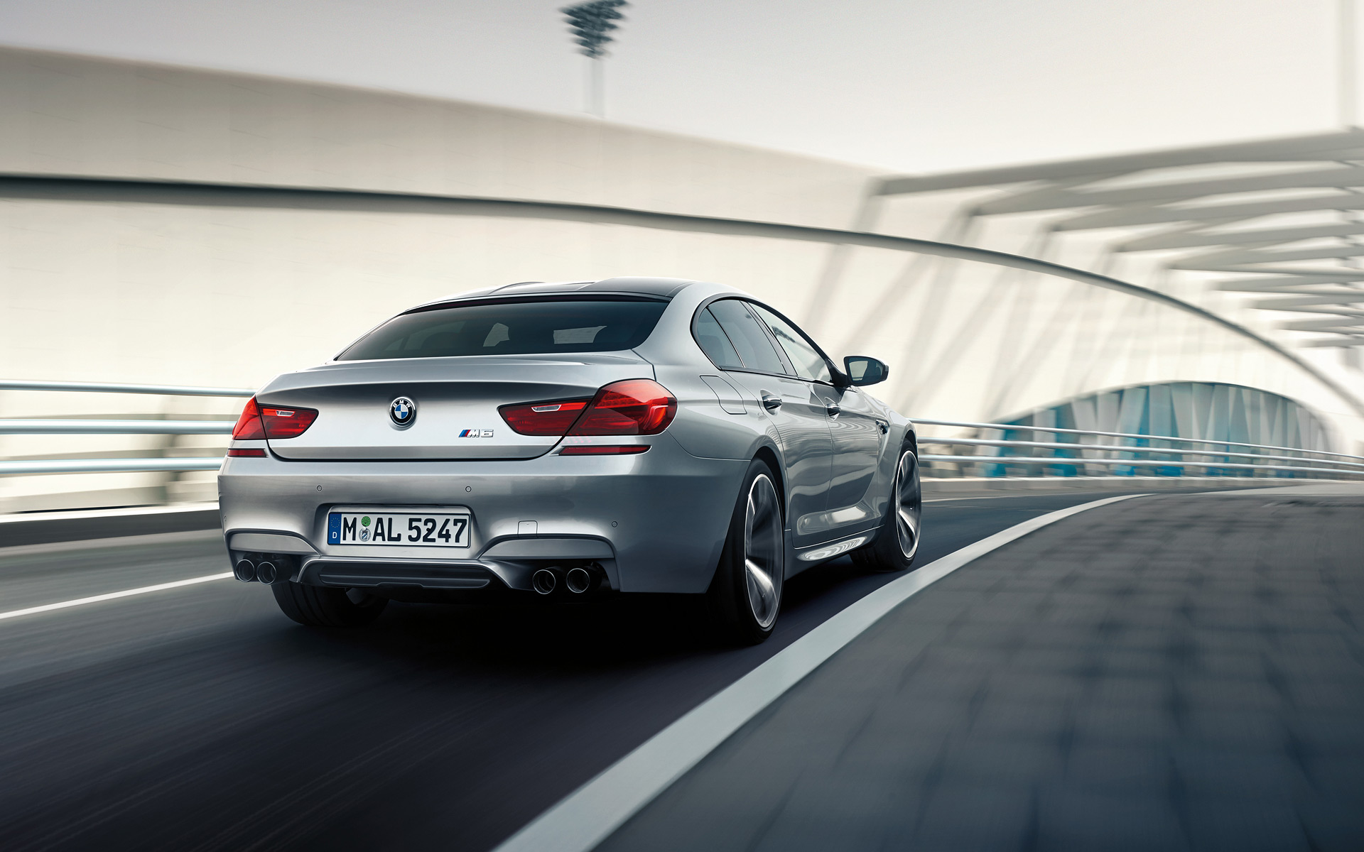 Essai sur route du Gran Coupé BMW M6 de Série M, carrosserie grise - vue arrière.