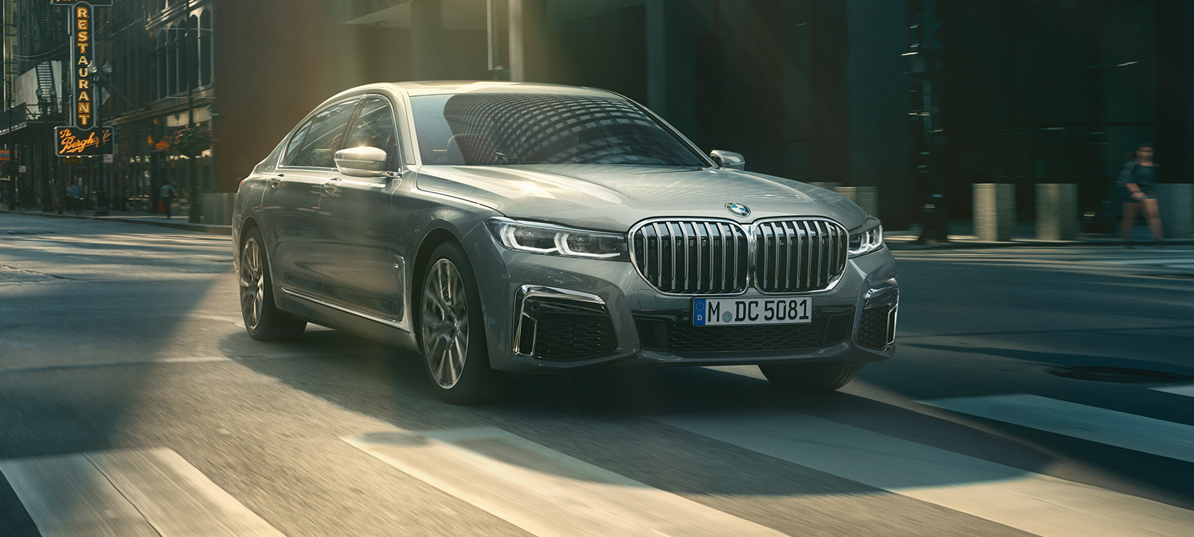 BMW M760Li xDrive Berline G11 G12 2019 Frozen Dark Silver metallic, vue de trois quarts arrière devant un décor urbain BMW M760Li xDrive Berline G11 G12 2019 Frozen Dark Silver metallic, vue de trois quarts arrière devant un décor urbain