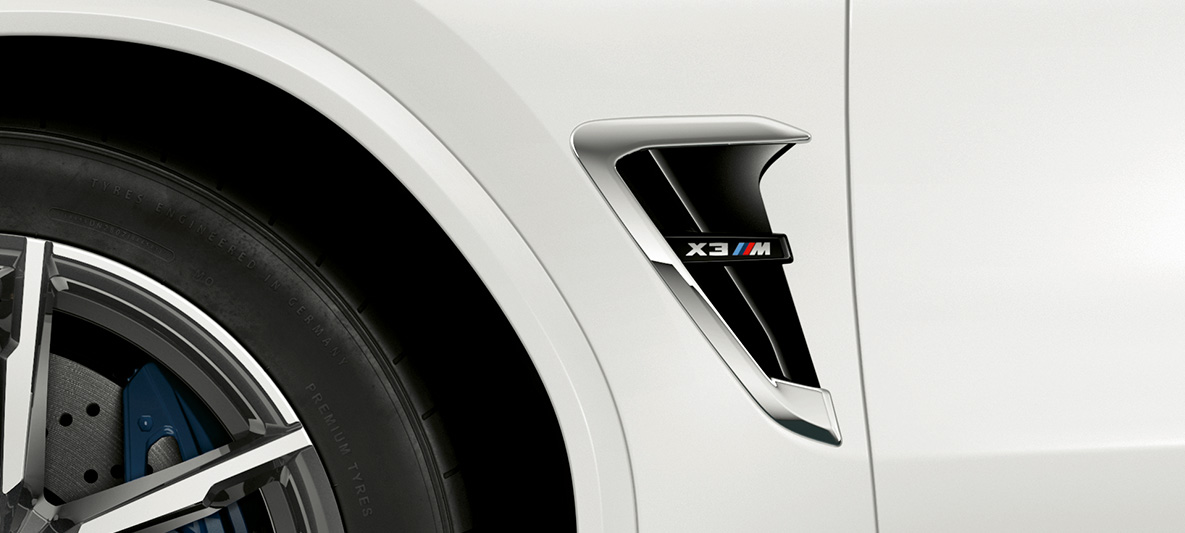 BMW X3 M, M gill. BMW X3 M in Alpine White, exterior, M gill with chrome highlights and model designation.
