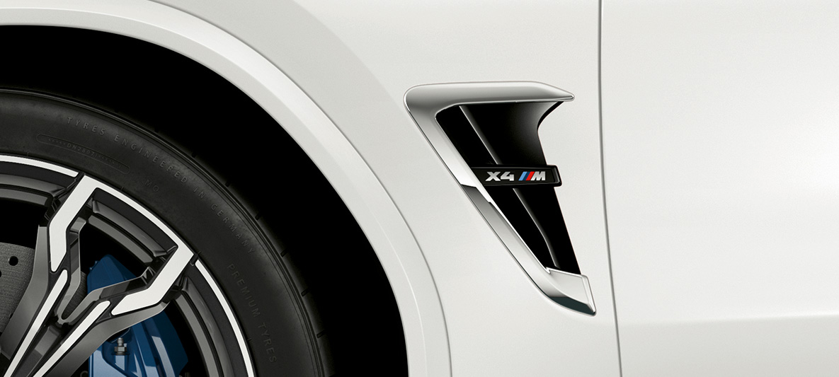 BMW X4 M, M gill. BMW X4 M in Alpine White, exterior, M gill with chrome highlights and model designation.