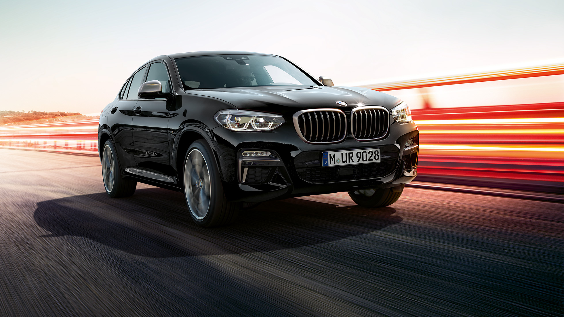 BMW X4 M40i, three-quarter front view. BMW X4 M40i in Black Sapphire metallic, exterior, three-quarter front view, left side with light strips.