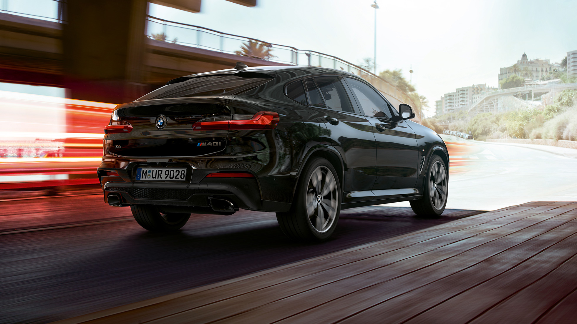 BMW X4 M40i, three-quarter rear view. BMW X4 M40i in Black Sapphire metallic, exterior, three-quarter rear view, right side with light strips.
