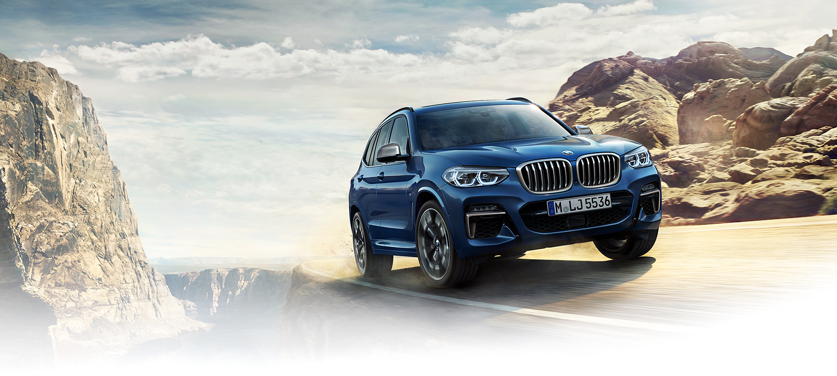 BMW X Series X3: bright blue risky turn on mountaintop. BMW X Series X3: bright blue risky turn on mountaintop.
