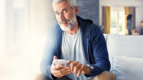 BMW ConnectedDrive BMW Store, homme assis avec smartphone dans les mains