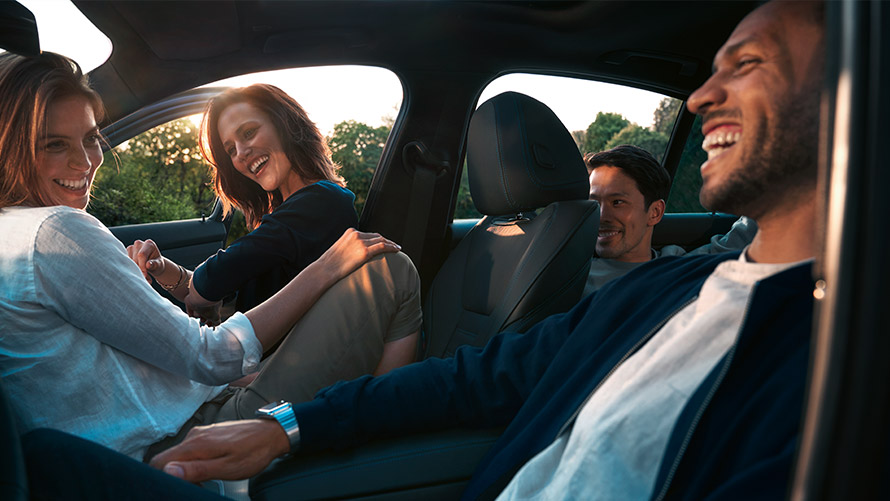 Friends laughing while sitting inside a BMW