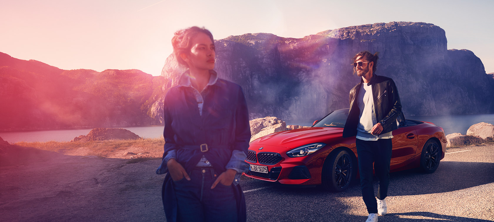 BMW three-quarter front view in front of mountain landscape with woman and man BMW Financial Services three-quarter front view in front of mountain landscape with woman and man