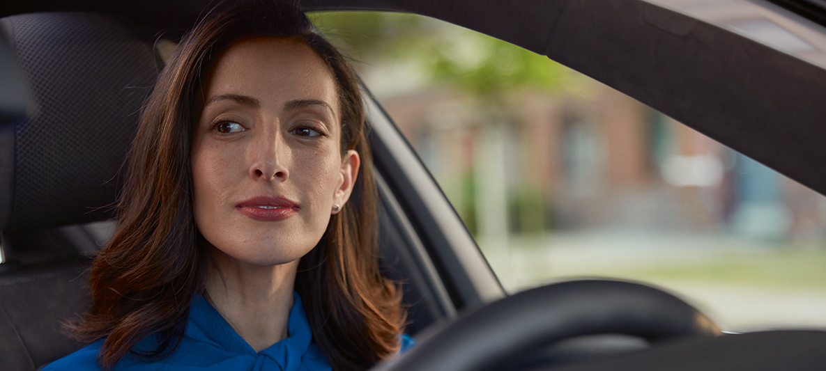 Une femme tout sourire au volant de sa BMW. Une femme tout sourire au volant de sa BMW.