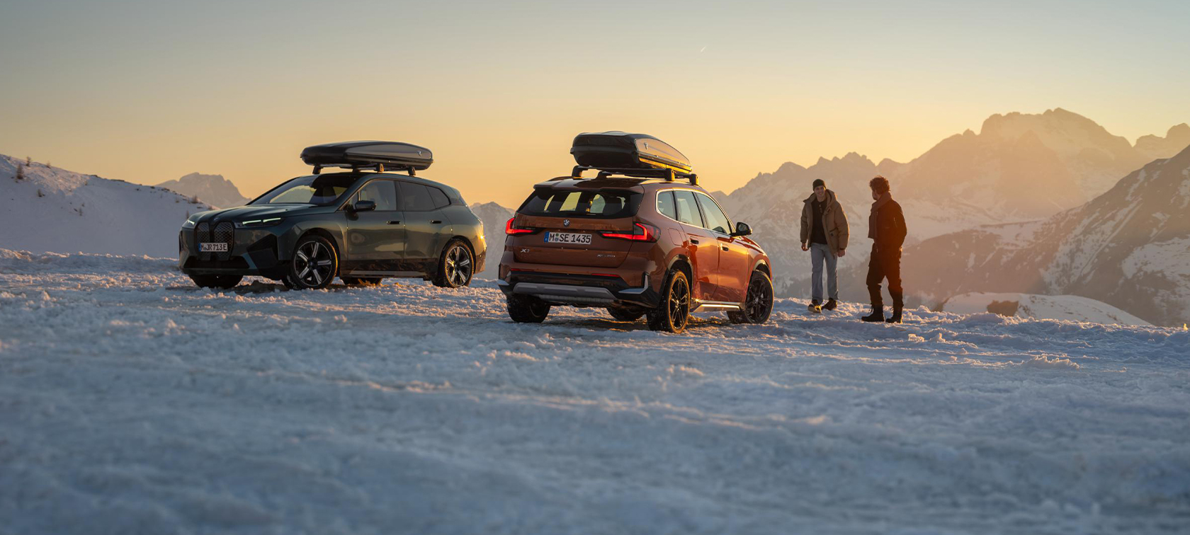 Accessoires BMW d’origine et Service BMW, automne-hiver homme rient dans la neige, devant une BMW