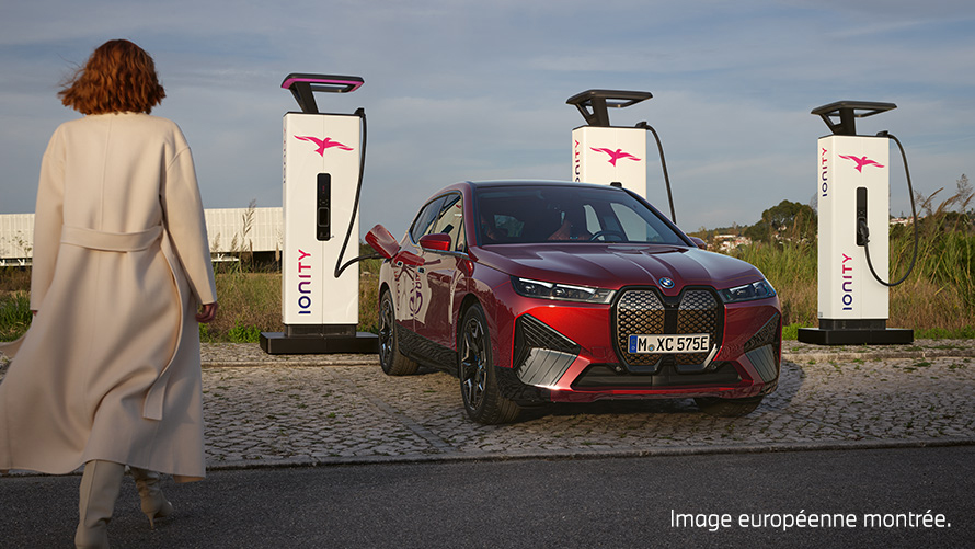 BMW Charging Solutions BMW Special Sales Sustainability Hub Overview BMW Special Sales Sustainability Hub Overview BMW Charging Solutions, véhicule BMW à la station de charge avec une femme au premier plan