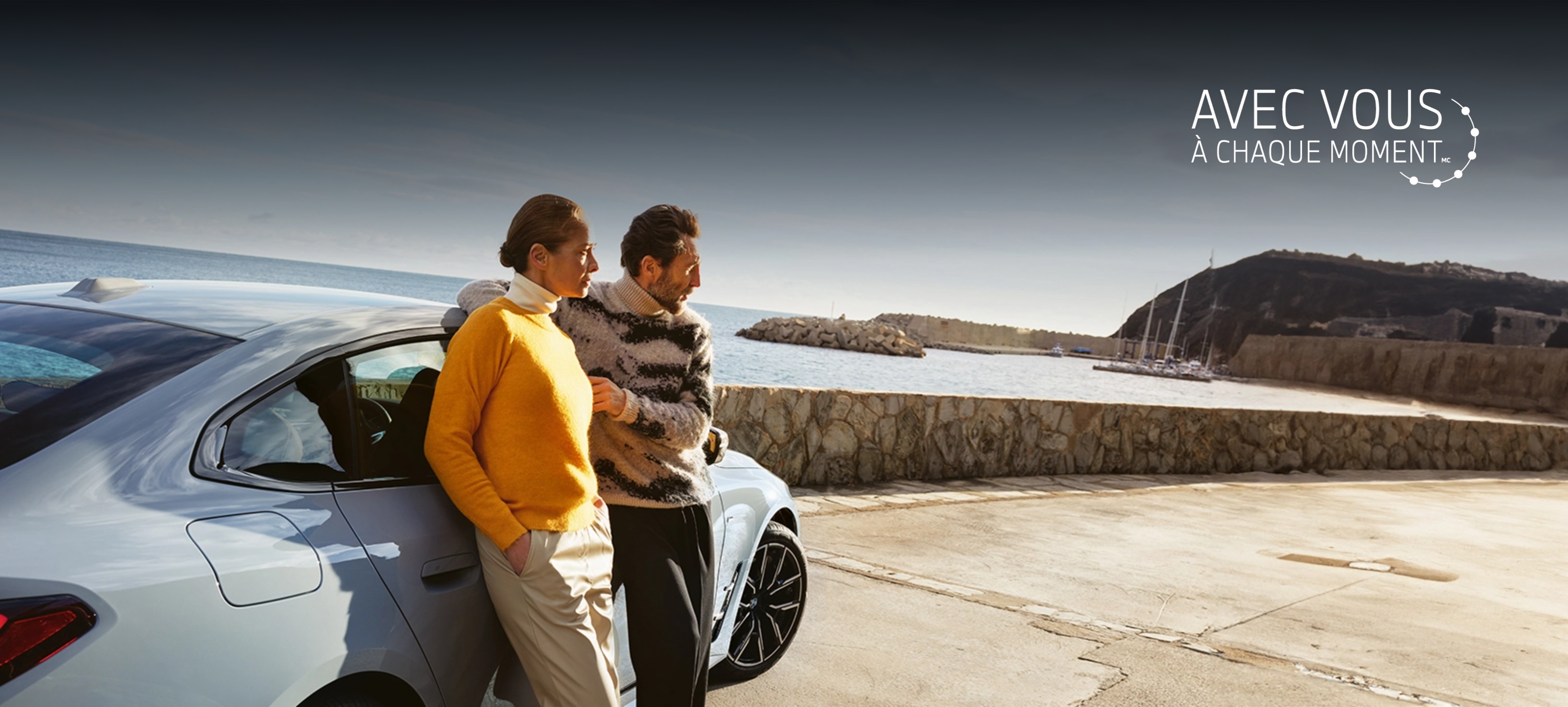 Resource Hub Header French man and woman talking behind BMW