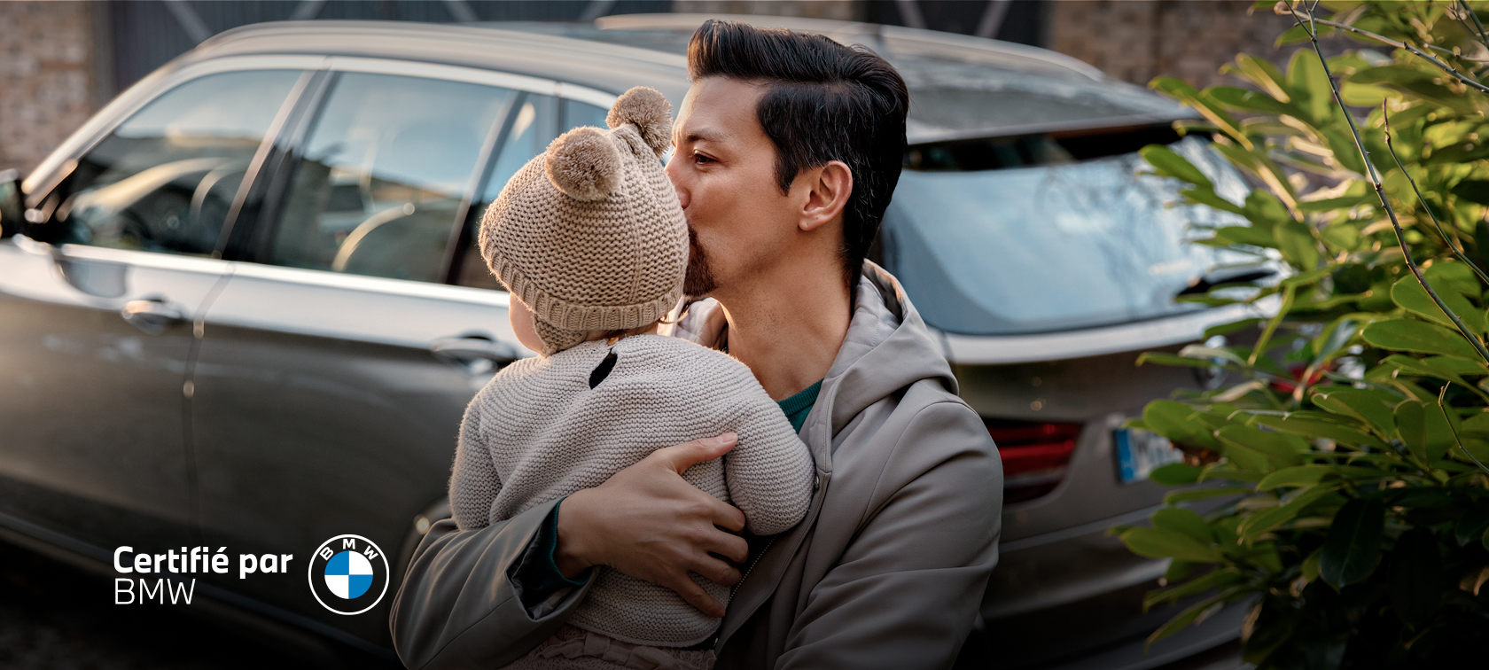 Man holding baby beside a BMW Man holding baby beside a BMW