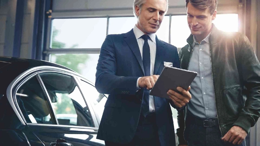 two men reviewing car history. 