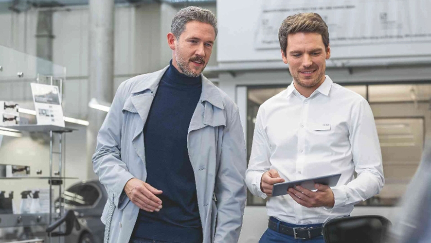 two men reviewing car history.