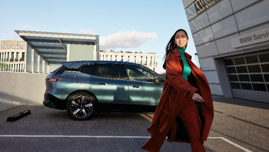 Woman walking away from BMW.